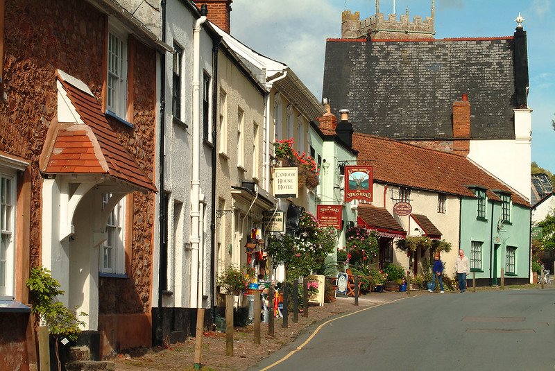 West Street in Dunster, with Exmoor House, the Stags Head sign and the church tower above the roofs