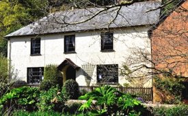 Dunster Mill House, with its white walls and climbing plants