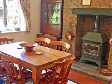 Dining table beside a wood-burning stove