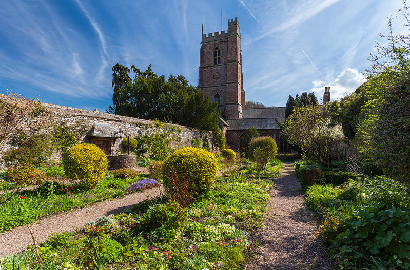 St George’s Church tower above the paths and planting in the church garden, Dunster